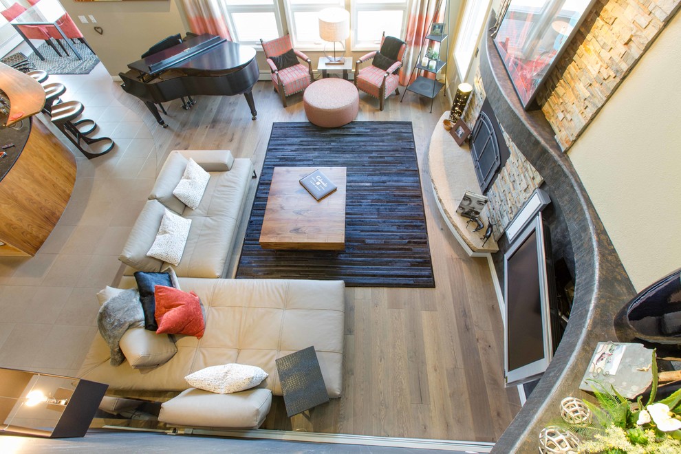 This is an example of a large contemporary open concept family room in Denver with black walls, medium hardwood floors and brown floor.
