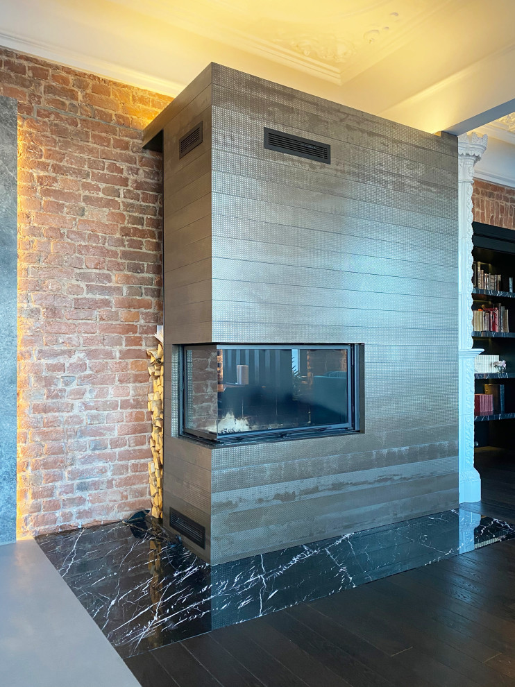 Expansive industrial kitchen/dining room in Saint Petersburg with black walls, dark hardwood flooring, a corner fireplace, a tiled fireplace surround, exposed beams and brick walls.