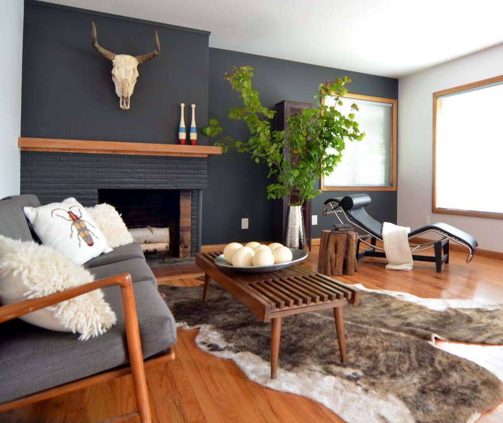 Photo of a contemporary living room in Portland with grey walls, medium hardwood floors, a brick fireplace surround and no tv.