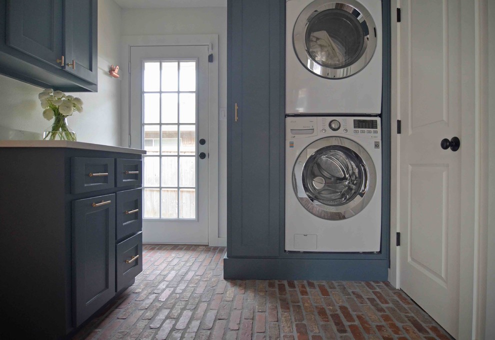 Small transitional dedicated laundry room in Dallas with shaker cabinets, grey cabinets, quartz benchtops, white walls, brick floors and a stacked washer and dryer.