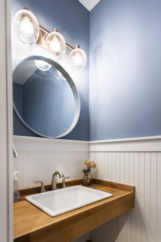 Cette photo montre un petit WC et toilettes chic en bois brun avec un mur bleu, un lavabo posé, un plan de toilette en bois, un plan de toilette marron et meuble-lavabo suspendu.