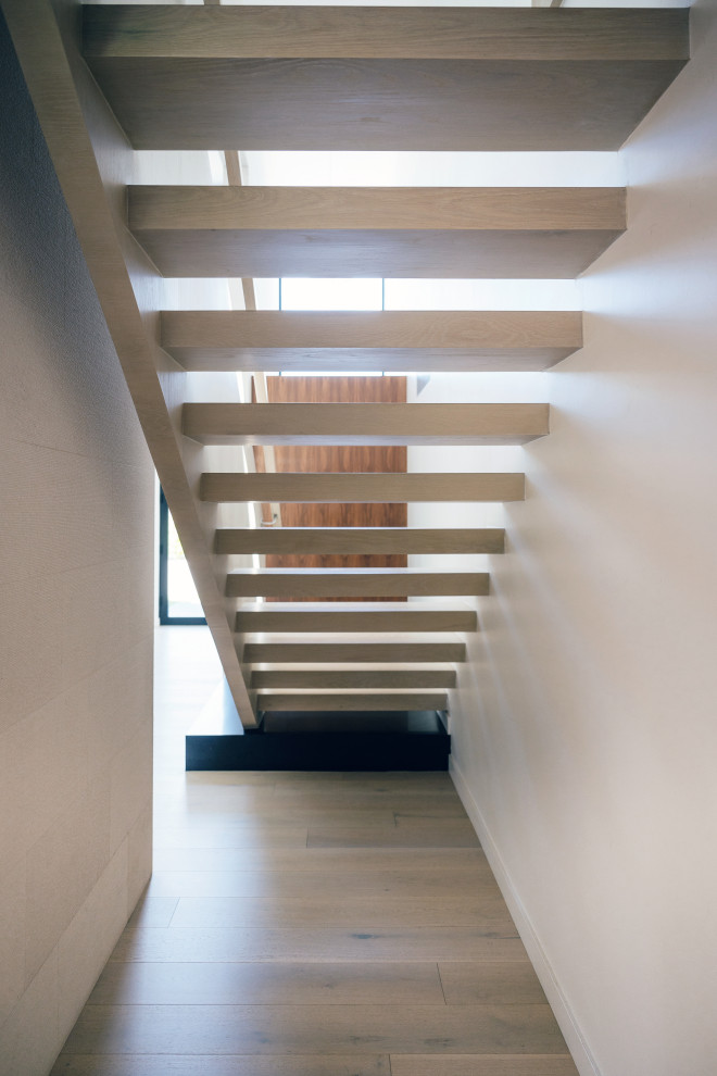Idées déco pour un escalier sans contremarche flottant rétro de taille moyenne avec des marches en bois, un garde-corps en bois et un mur en parement de brique.
