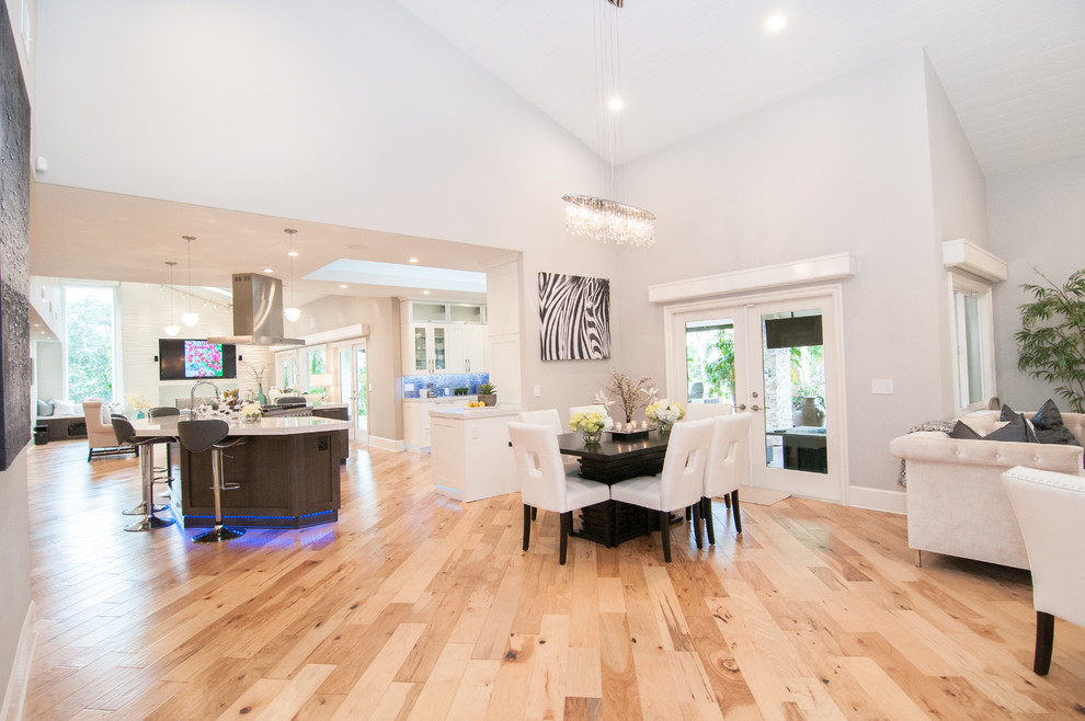 This is an example of a mid-sized modern open plan dining in San Diego with grey walls, light hardwood floors and no fireplace.