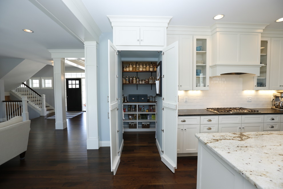 Inspiration for a large arts and crafts l-shaped eat-in kitchen in Cedar Rapids with a farmhouse sink, shaker cabinets, white cabinets, granite benchtops, blue splashback, ceramic splashback, stainless steel appliances, dark hardwood floors and with island.