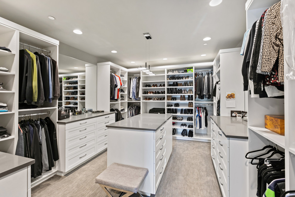 Modelo de vestidor unisex extra grande con armarios con paneles empotrados, puertas de armario blancas, moqueta y suelo gris
