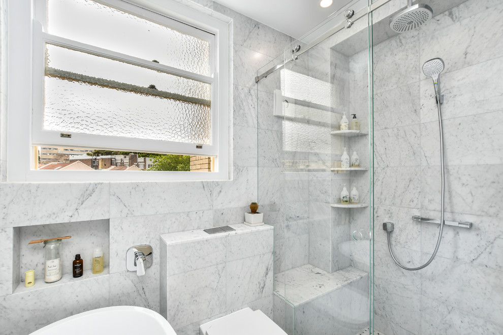 Small contemporary bathroom in Sydney with black cabinets, a freestanding tub, an alcove shower, a wall-mount toilet, gray tile, grey walls, mosaic tile floors and a sliding shower screen.