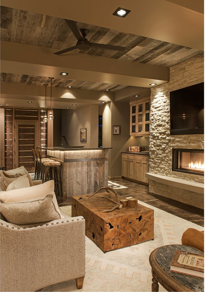 Design ideas for a large country open concept family room in Other with a home bar, a ribbon fireplace, a stone fireplace surround, a wall-mounted tv, grey walls, dark hardwood floors and brown floor.