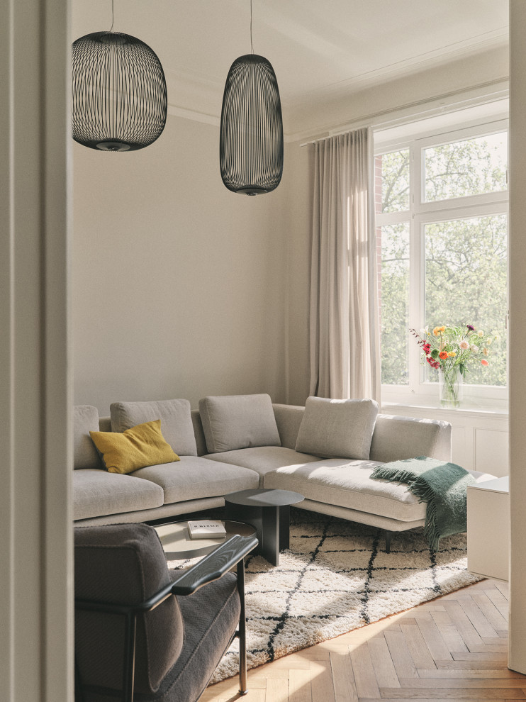 Wohnzimmer With grauer Wandfarbe, hellem Holzboden and beigem Boden in Hamburg
