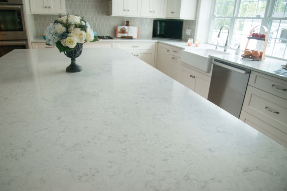 Transitional l-shaped eat-in kitchen photo in Providence with a farmhouse sink, quartzite countertops, ceramic backsplash, stainless steel appliances and an island