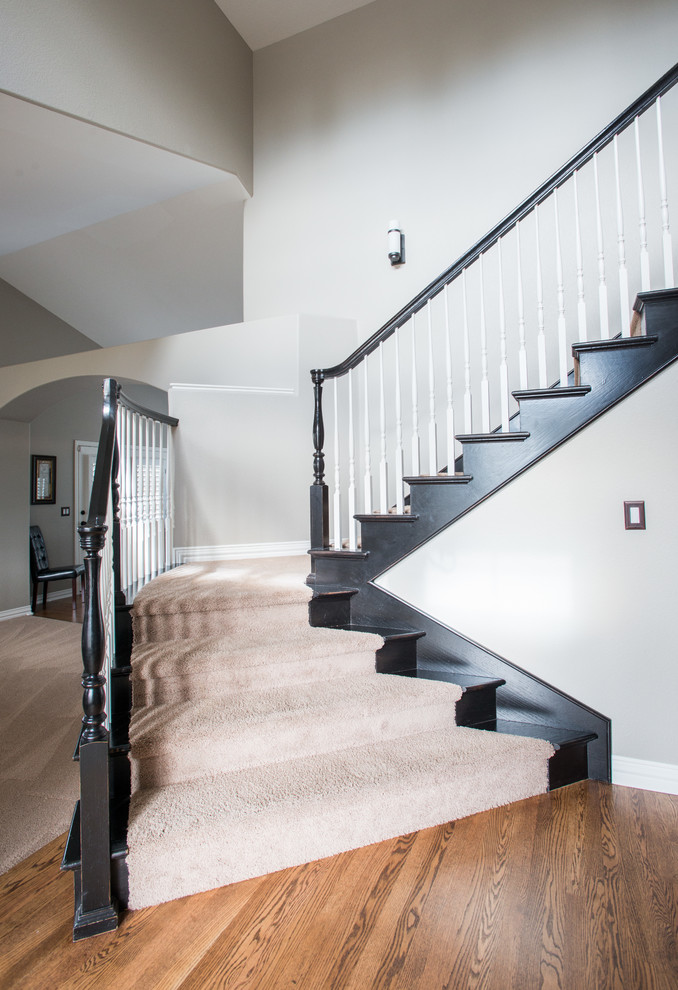 Inspiration for a large traditional carpeted l-shaped staircase in Denver with carpet risers and wood railing.