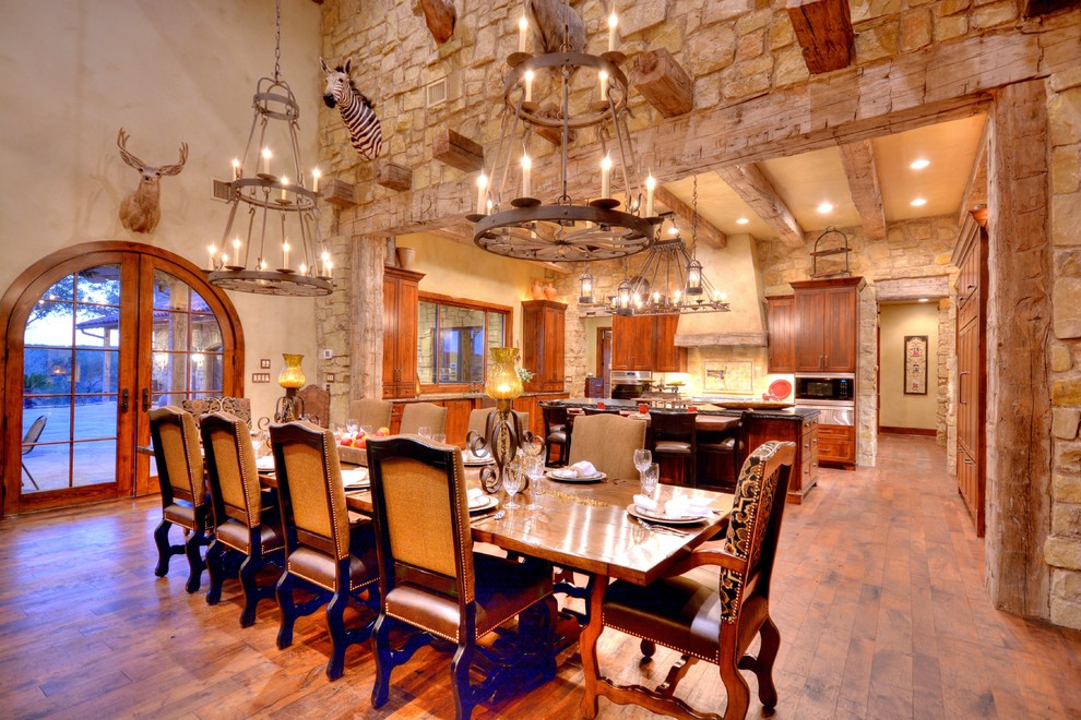 Mountain style u-shaped medium tone wood floor eat-in kitchen photo in Austin with a farmhouse sink, beaded inset cabinets, medium tone wood cabinets, granite countertops, stainless steel appliances and an island