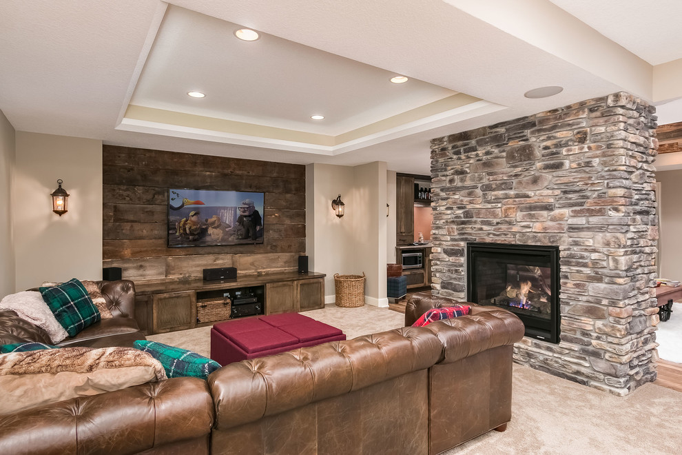 Mid-sized country walk-out basement in Minneapolis with beige walls, medium hardwood floors, a two-sided fireplace, a stone fireplace surround and brown floor.