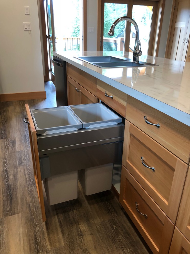 Small arts and crafts l-shaped eat-in kitchen in Vancouver with a drop-in sink, shaker cabinets, laminate benchtops, black appliances, laminate floors, with island, grey floor and white benchtop.
