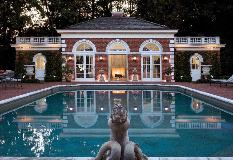 This is an example of a large traditional custom-shaped lap pool in Boston with brick pavers.