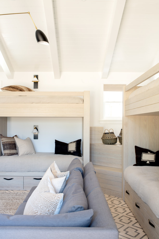 This is an example of a beach style gender-neutral kids' room in Los Angeles with white walls and white floor.