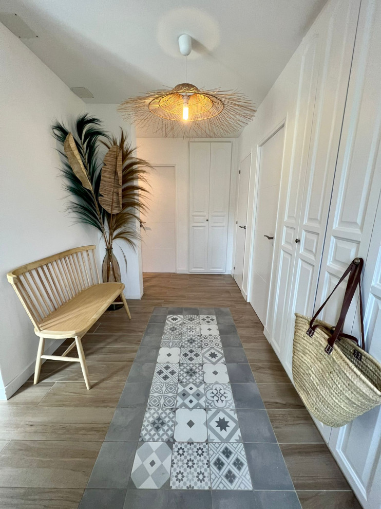 Foto di un grande ingresso minimalista con pareti bianche, pavimento con piastrelle in ceramica e soffitto a cassettoni