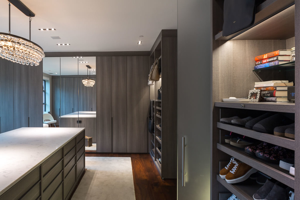 This is an example of an expansive contemporary women's walk-in wardrobe in DC Metro with flat-panel cabinets, medium wood cabinets, carpet and beige floor.