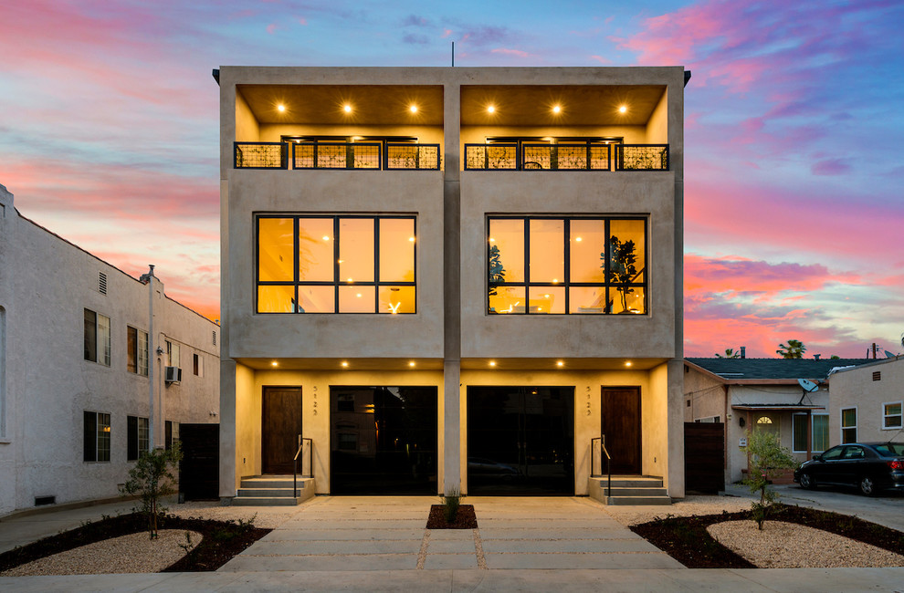 This is an example of a large contemporary three-storey stucco duplex exterior in Los Angeles.