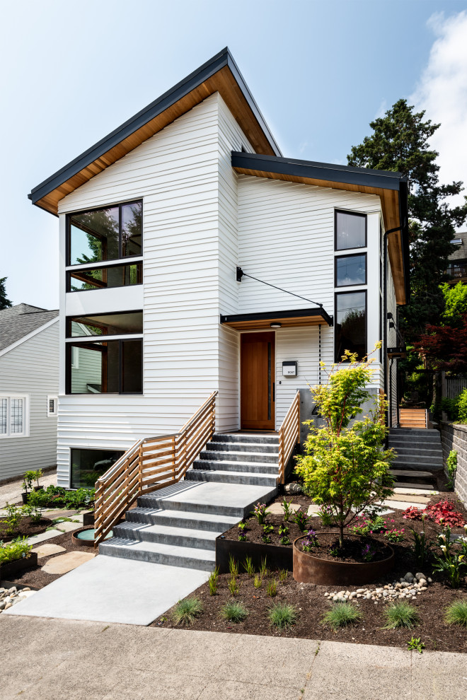 Design ideas for a large contemporary three-storey white house exterior in Seattle with wood siding, a shed roof and a metal roof.