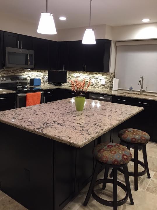 Example of a large transitional l-shaped porcelain tile eat-in kitchen design in Detroit with an undermount sink, shaker cabinets, dark wood cabinets, quartzite countertops, brown backsplash, mosaic tile backsplash, stainless steel appliances and an island