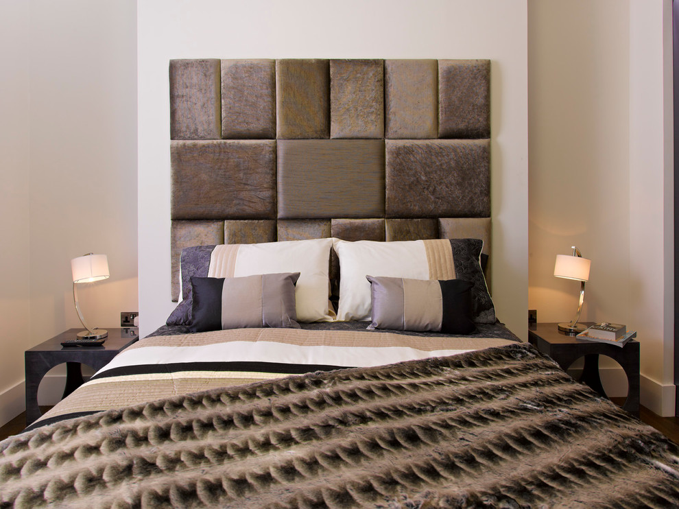 Contemporary bedroom in London with beige walls and dark hardwood floors.