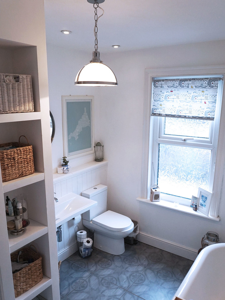 Inspiration for a large beach style kids bathroom in Manchester with white cabinets, a claw-foot tub, an open shower, a one-piece toilet, gray tile, porcelain tile, white walls, porcelain floors and a wall-mount sink.