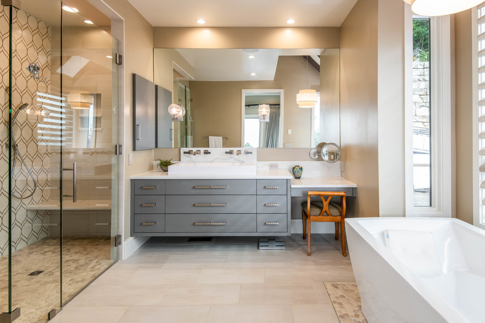 This is an example of a large midcentury master bathroom in Other with flat-panel cabinets, grey cabinets, a freestanding tub, multi-coloured tile, beige walls, a trough sink, beige floor, a hinged shower door, white benchtops, an alcove shower, porcelain floors and quartzite benchtops.