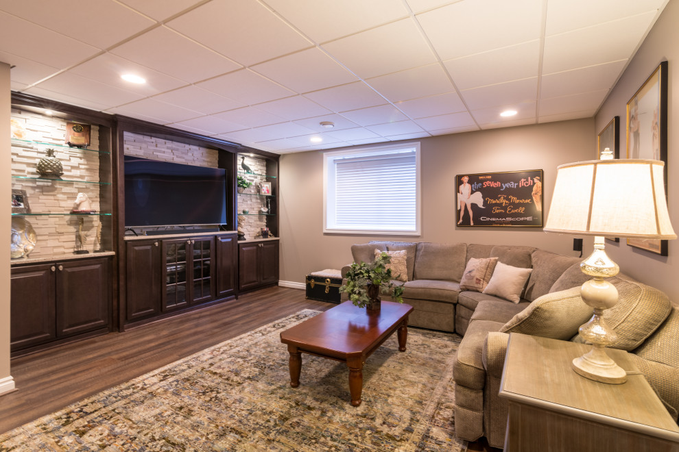 This is an example of a large transitional look-out basement in Chicago with beige walls, medium hardwood floors, no fireplace and brown floor.
