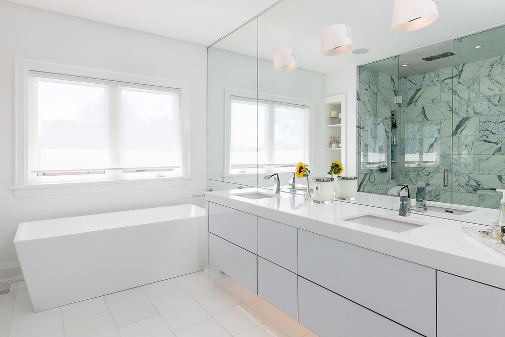 Design ideas for a contemporary bathroom in Toronto with flat-panel cabinets, white cabinets, a freestanding tub, white walls and an undermount sink.