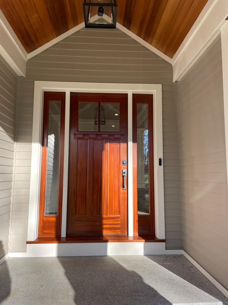 Modelo de puerta principal abovedada de estilo americano grande con paredes beige, suelo de granito, puerta simple, puerta de madera en tonos medios, suelo gris y madera