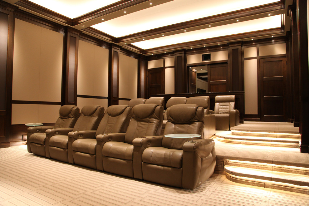 This is an example of a large contemporary enclosed home theatre in Omaha with brown walls, carpet, a projector screen and beige floor.