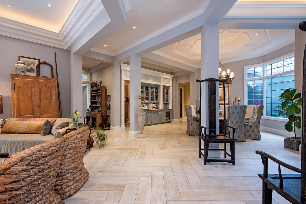 Immagine di un ampio soggiorno mediterraneo aperto con angolo bar, pareti grigie, parquet chiaro, pavimento marrone e soffitto ribassato