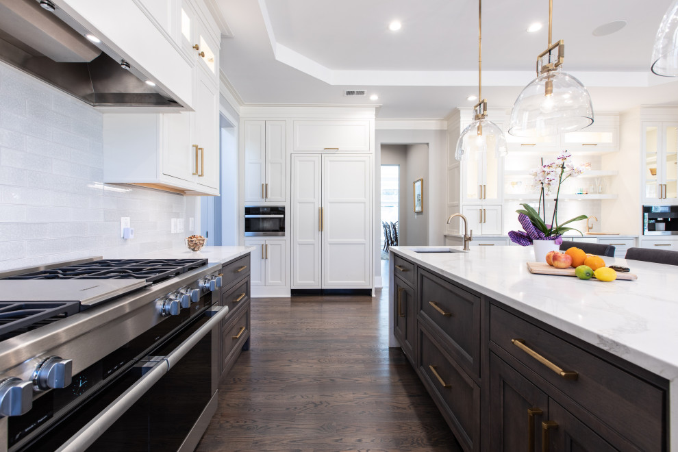 Inspiration for a large transitional u-shaped open plan kitchen in DC Metro with a single-bowl sink, beaded inset cabinets, white cabinets, quartz benchtops, white splashback, ceramic splashback, panelled appliances, dark hardwood floors, with island, brown floor, white benchtop and recessed.