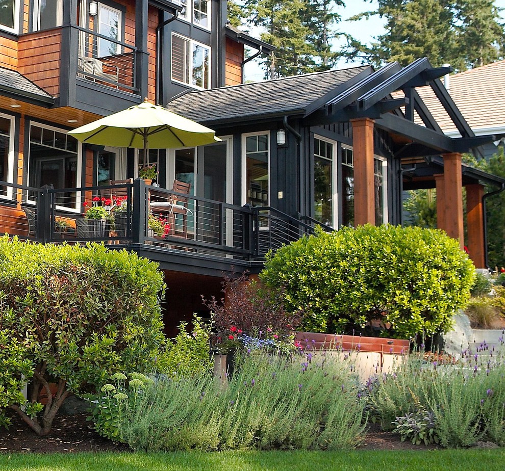 Photo of a country three-storey black exterior in Seattle with wood siding.