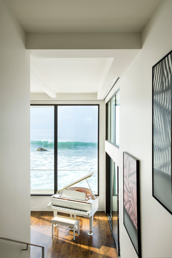 Living room - transitional medium tone wood floor living room idea in Los Angeles with a music area and white walls