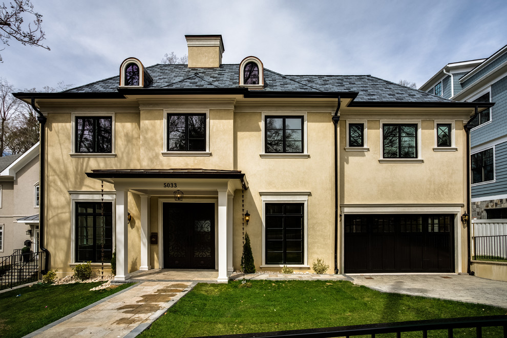 Large traditional three-storey stucco beige house exterior in DC Metro with a hip roof and a tile roof.