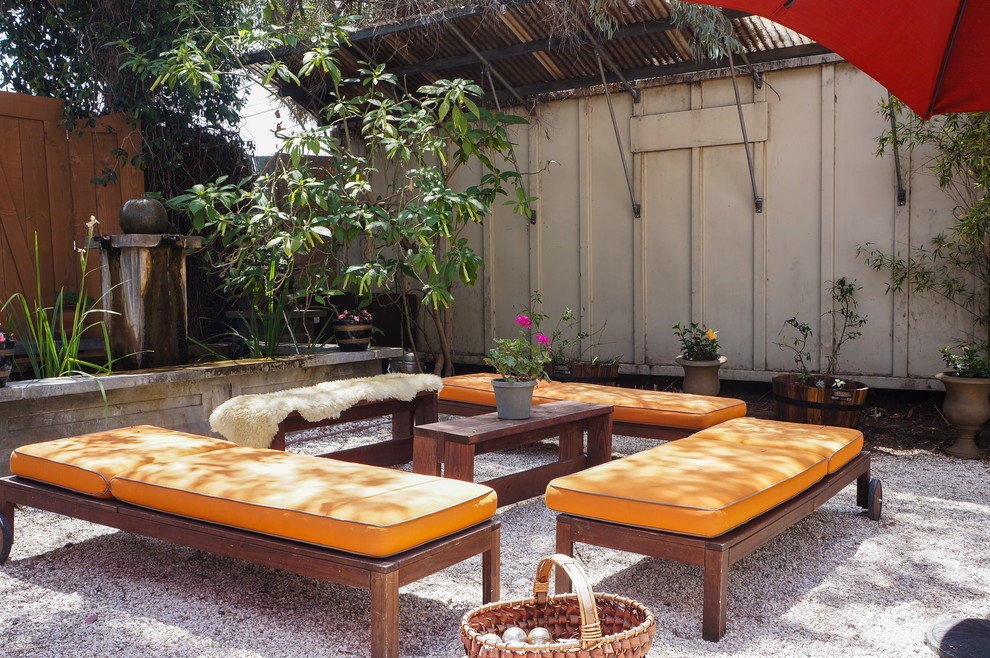 Inspiration for an industrial backyard patio in Los Angeles with a container garden and gravel.