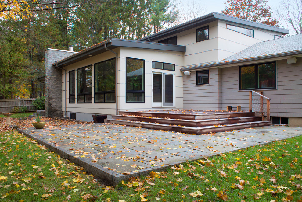 Inspiration for a mid-sized midcentury two-storey white exterior in Denver with mixed siding and a flat roof.