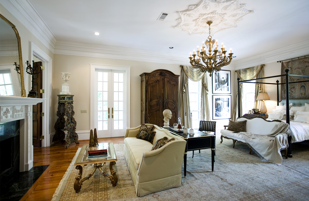 Design ideas for a large traditional master bedroom in Atlanta with beige walls, medium hardwood floors, a standard fireplace and a plaster fireplace surround.