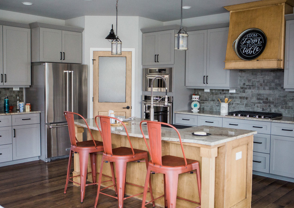 Inspiration for a mid-sized transitional kitchen remodel with a farmhouse sink, granite countertops, gray backsplash, stainless steel appliances and an island