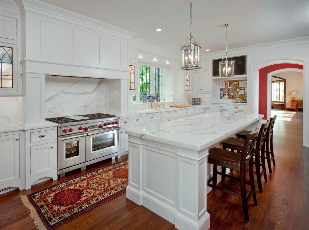 Photo of a large traditional kitchen in Cincinnati with recessed-panel cabinets, white cabinets, white splashback, stainless steel appliances and dark hardwood floors.