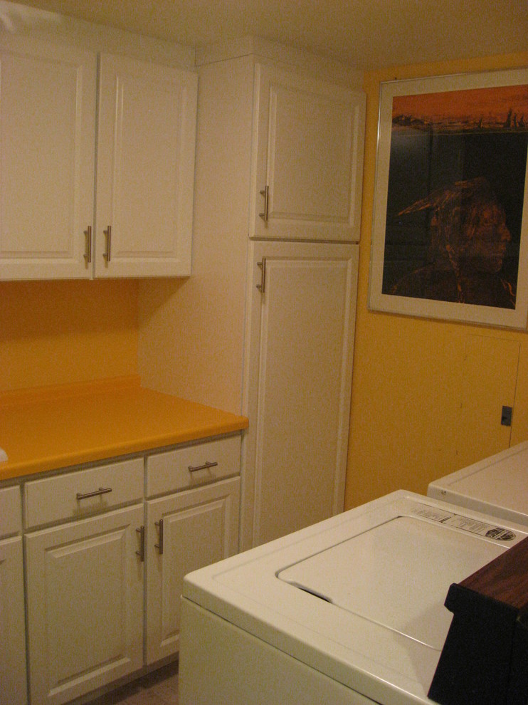 Example of a small eclectic galley ceramic tile dedicated laundry room design in Denver with a single-bowl sink, raised-panel cabinets, white cabinets, laminate countertops, orange walls and a side-by-side washer/dryer