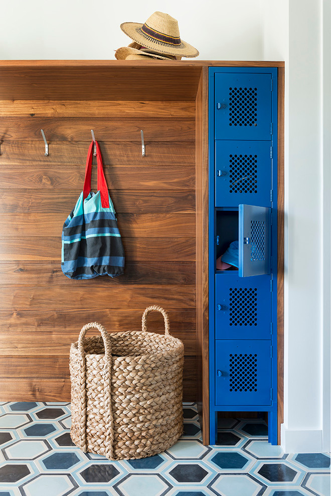 This is an example of a beach style mudroom in Boston with white walls.