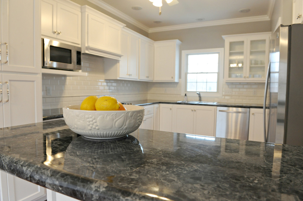 Inspiration for a transitional u-shaped eat-in kitchen remodel in Chicago with a drop-in sink, flat-panel cabinets, white cabinets, laminate countertops, white backsplash and subway tile backsplash