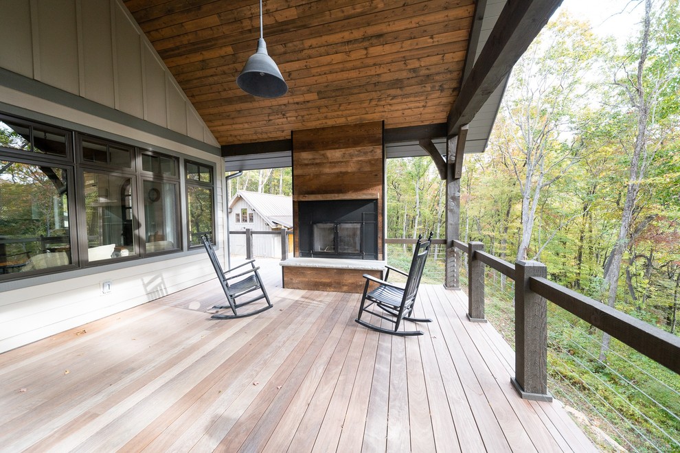 Photo of a country backyard deck in Other with with fireplace and a roof extension.