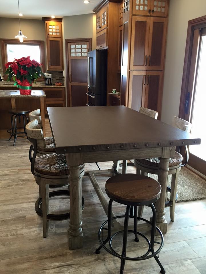 Large transitional l-shaped eat-in kitchen photo with a single-bowl sink, brown cabinets, granite countertops, brown backsplash, stainless steel appliances and an island