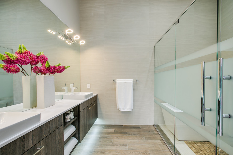 Design ideas for a large contemporary master bathroom in Seattle with flat-panel cabinets, dark wood cabinets, a freestanding tub, a shower/bathtub combo, beige tile, a vessel sink, beige floor, a hinged shower door, white benchtops, a double vanity and a floating vanity.