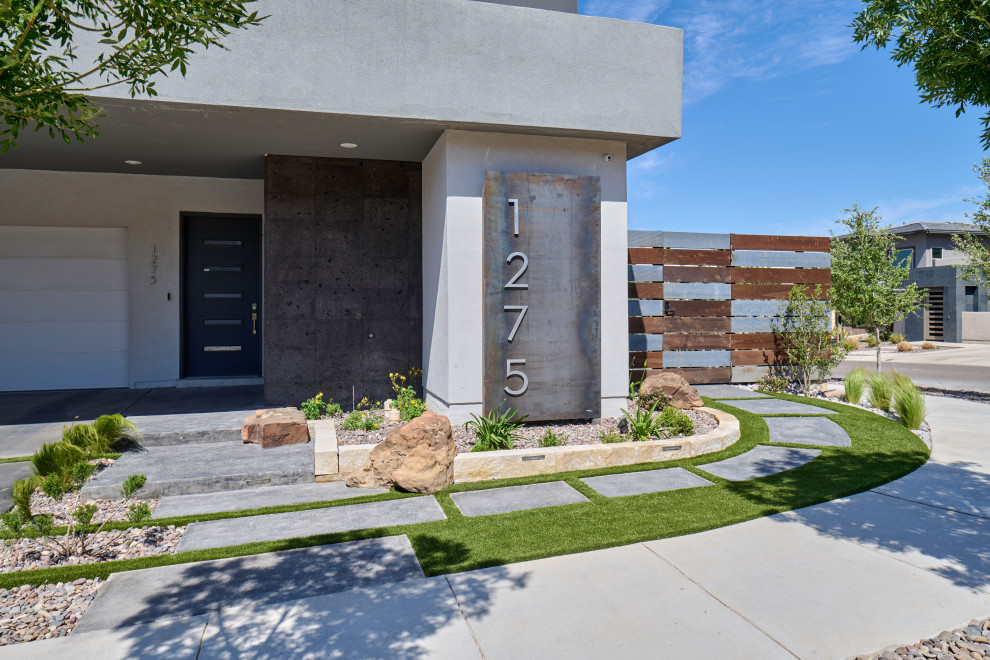 This is an example of a small contemporary front yard garden in Other with with path, concrete pavers and a wood fence.