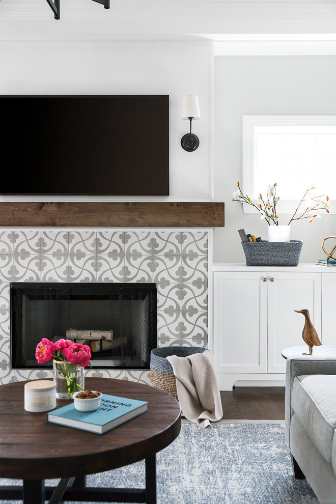 Inspiration for a mid-sized beach style open concept living room in Chicago with grey walls, a standard fireplace, a tile fireplace surround, a wall-mounted tv and brown floor.
