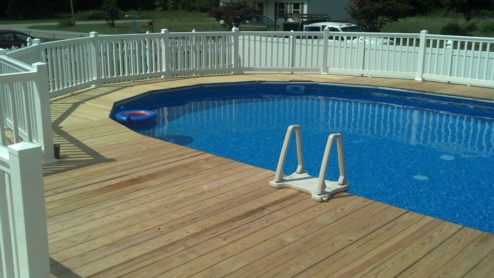 Mid-sized traditional backyard round aboveground pool in Other with decking.